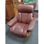 A brown leather revolving and reclining armchair