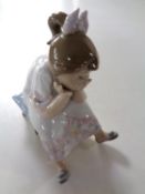 A Lladro figure depicting a girl on footstool