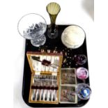 A tray of glass paperweights, place mats, cased set of cutlery,