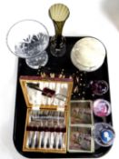 A tray of glass paperweights, place mats, cased set of cutlery,