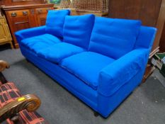 A contemporary three seater settee in blue corded fabric