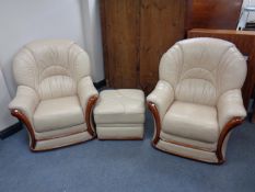 A pair of cream leather armchairs with matching footstool