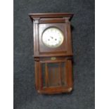 An early 20th century oak cased wall clock with silvered dial