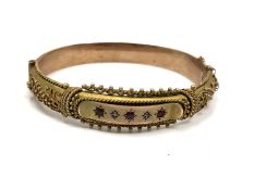 An antique 9ct gold bangle set with synthetic rubies, 15.