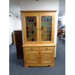 A continental light oak glazed cabinet