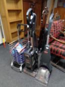 A Shark vacuum together with a Bissel carpet cleaner and a trolley containing shaver and two books