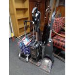 A Shark vacuum together with a Bissel carpet cleaner and a trolley containing shaver and two books