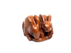 A carved Chinese hardwood netsuke - Two rabbits