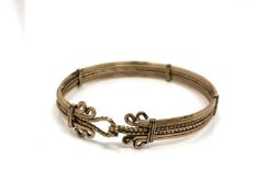 An antique gold plated spring loaded bangle