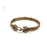 An antique gold plated spring loaded bangle