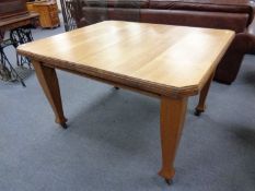 An Edwardian extending dining table and four oak chairs