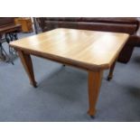 An Edwardian extending dining table and four oak chairs