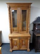 A 19th century oak glazed bookcase with covered base