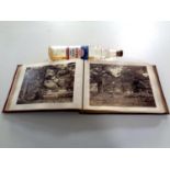 A tooled leather album containing monochrome photographs, rural scenes,
