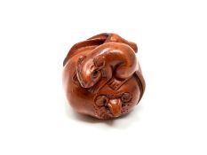 A carved Chinese hardwood netsuke - Two rats eating a large fruit
