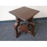 A 19th century occasional table on heavily carved figured legs