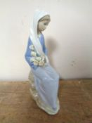 A Lladro figure depicting a lady holding flowers