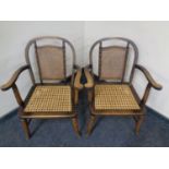 A pair of early 20th century stained beech and bergere armchairs with simulated bamboo frames