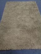 A contemporary olive shaggy pile rug