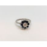 An 18ct white gold diamond and sapphire cluster ring, the central stone approximately 0.3ct, size M.