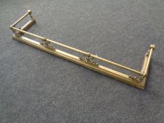 A Victorian brass fire curb