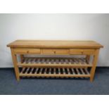 A contemporary light oak kitchen three drawer side table with under stretcher