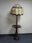 A mahogany standard lamp table with shade