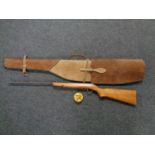 An air rifle in brown suede stitched carry case with part tin of pellets, .