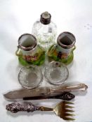 A cut glass silver rimmed perfume bottle together with a pair of cut glass silver rimmed salts,