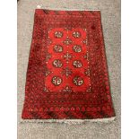 An Afghan Bokhara rug on red ground,