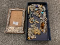 A silver mounted photograph frame, together with costume jewellery including brooches,