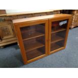 A mid century teak double door glazed cabinet