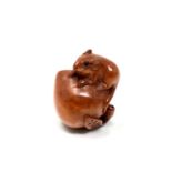 A carved Chinese hardwood netsuke - Rat standing on a peach