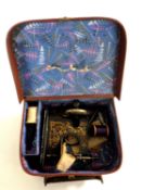 A small cased miniature sewing machine