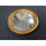 An antique circular gilt framed mirror