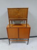 A 20th century teak shutter door low cabinet together with a teak fall front cabinet