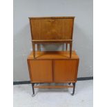 A 20th century teak shutter door low cabinet together with a teak fall front cabinet