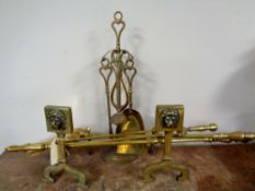 A pair of antique brass fire dogs together with three companion pieces,