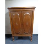 An early 20th century continental oak double door cabinet on turned legs