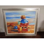 A contemporary silvered framed oil on canvas depicting a boy playing on a beach