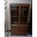 An early 20th century glazed oak bookcase fitted cupboards beneath