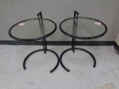 A pair of metal and glass circular lamp tables