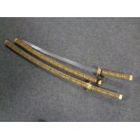 A pair of reproduction samurai swords in scabbards