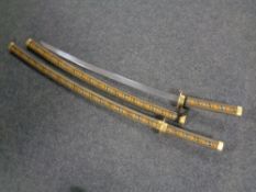 A pair of reproduction samurai swords in scabbards