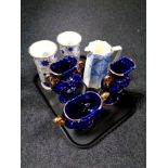 A tray containing Italian blue and gilt three piece mantel garniture set,