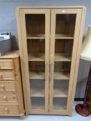 A contemporary oak effect glazed double door bookcase