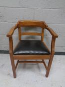 A mahogany armchair with black vinyl seat