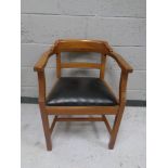 A mahogany armchair with black vinyl seat