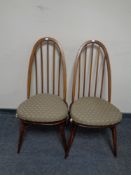 A pair of Ercol spindle back dining chairs with cushions