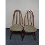 A pair of Ercol spindle back dining chairs with cushions